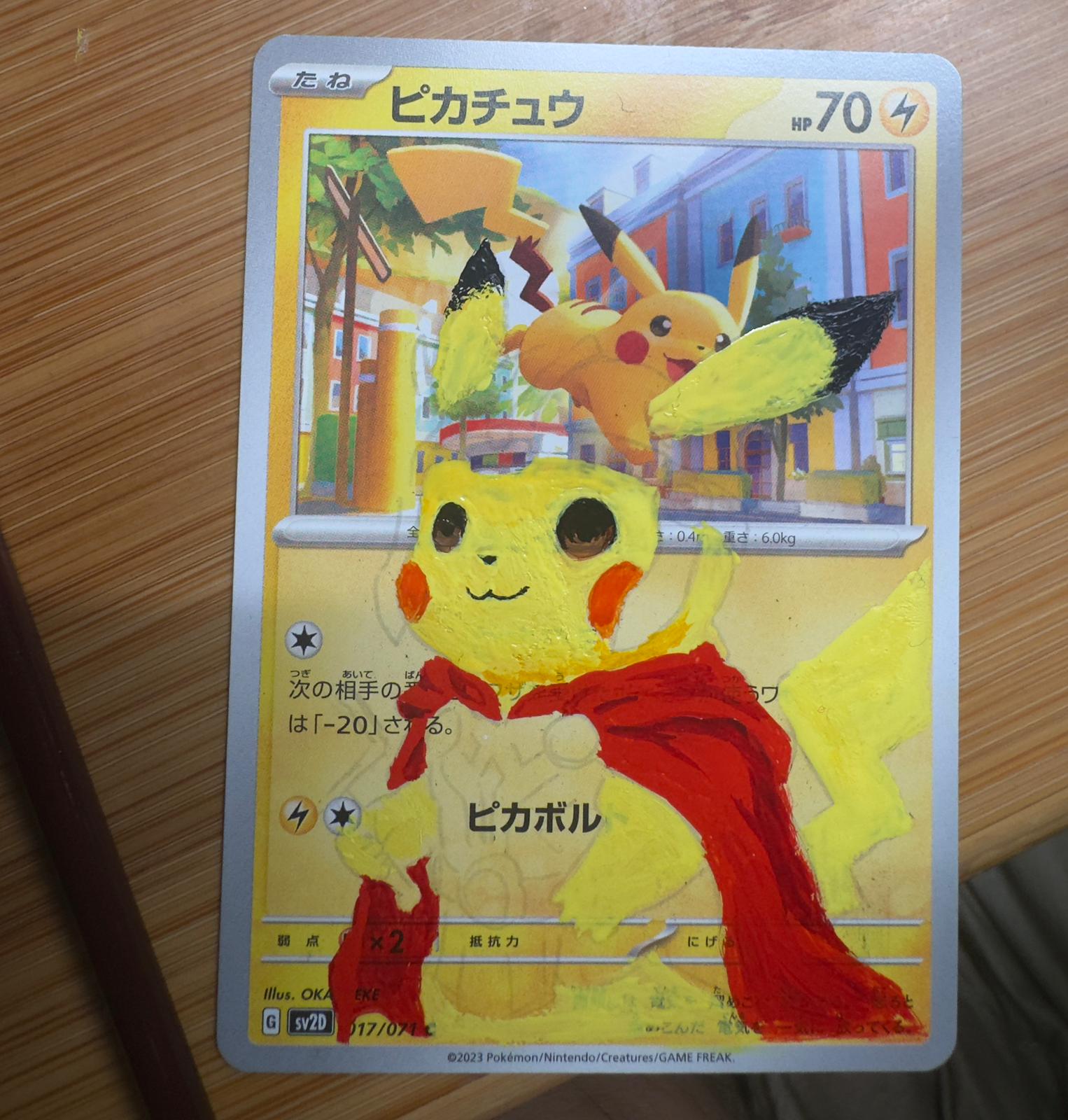 Stage two: Pikachu and the red cape begin to take shape around the card.