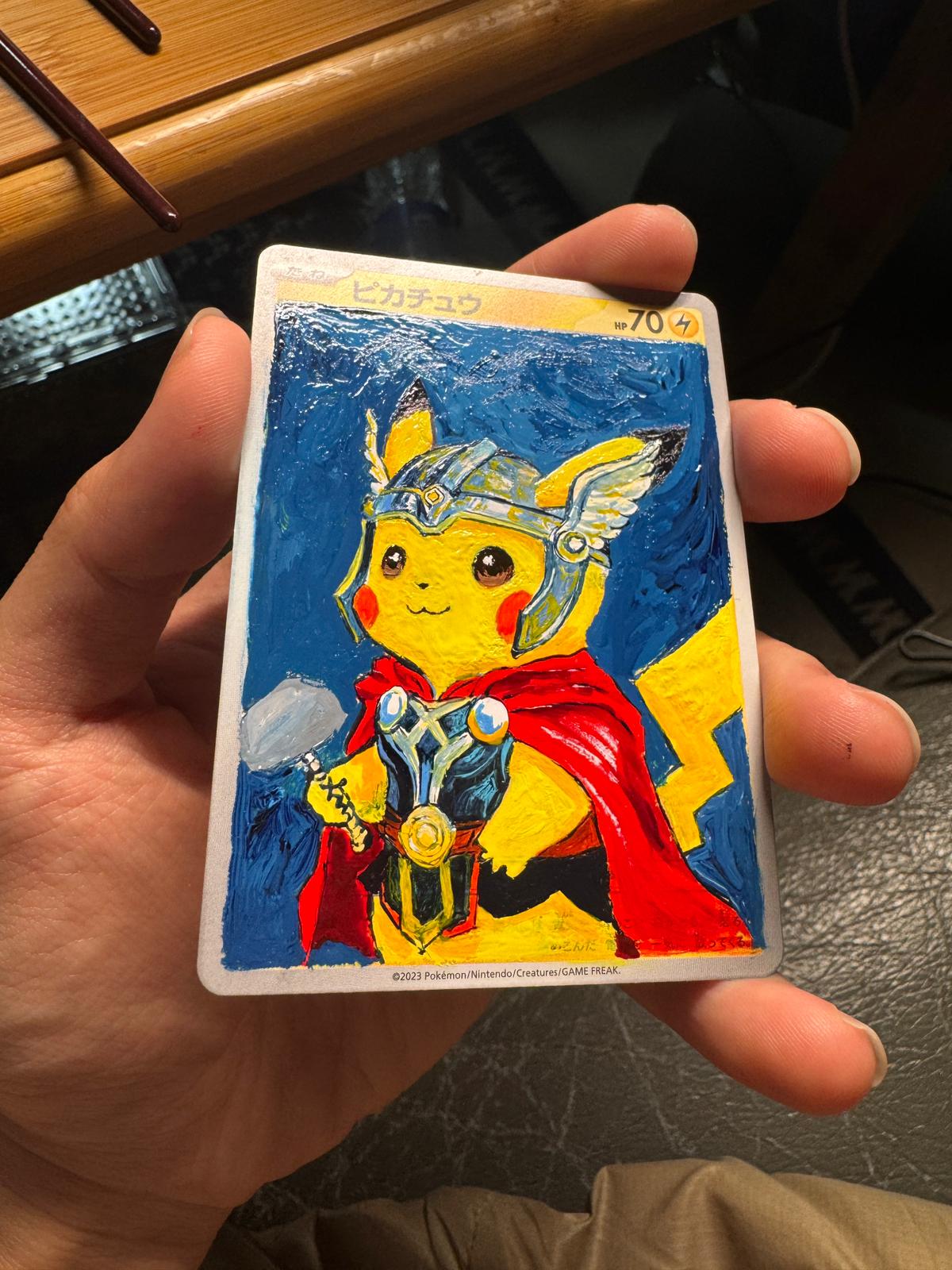 Stage four: the nearly completed Thor-inspired Pikachu artwork is held in hand.